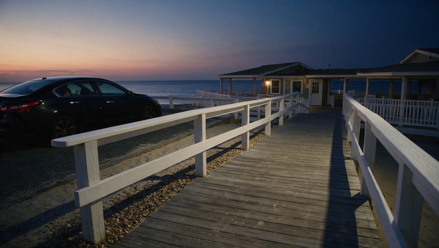 A Jersey Shore beach club boardwalk at dusk with a black sedan parked on the drive